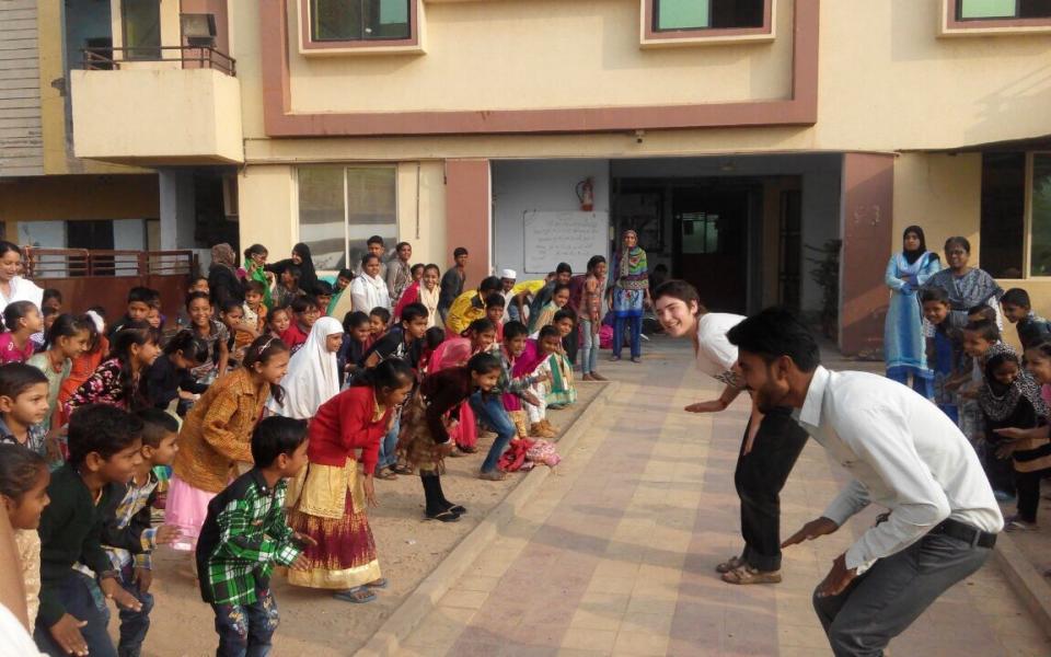 Students at a school in Ahmedabad, India participate in a group warm-up during a URI Environmental Workshop. 