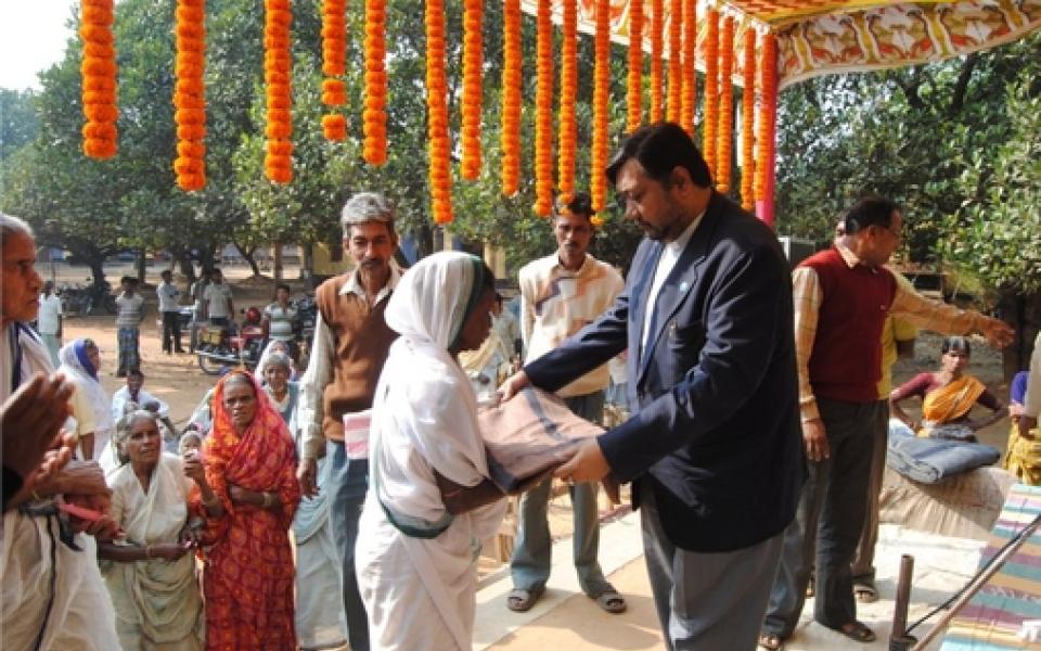 A woman handing out blanket to a man 