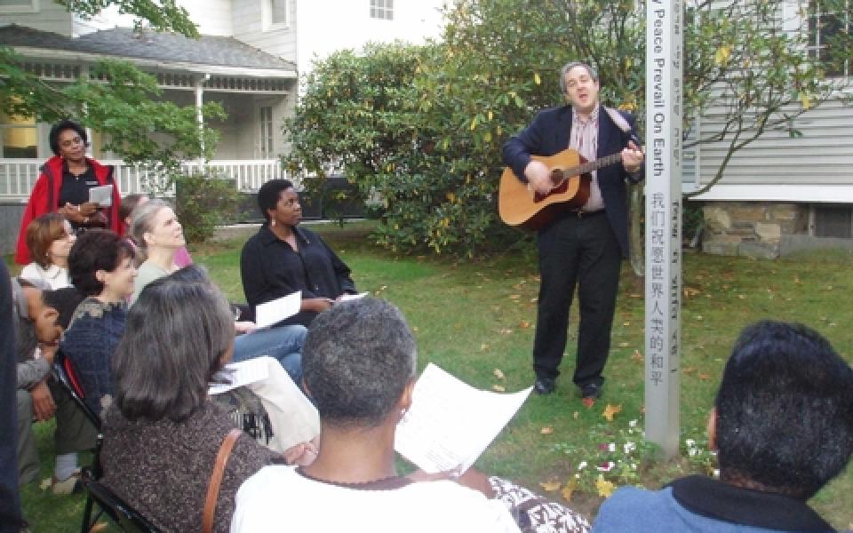 Paul singing to a group of people outdoor 