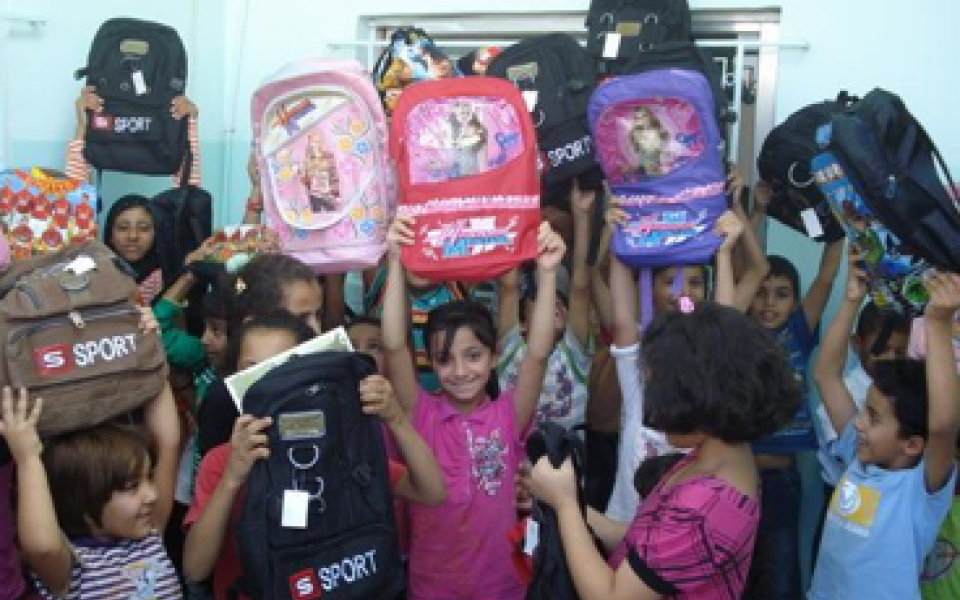 young children are holding their pack back Ramadan gifts 