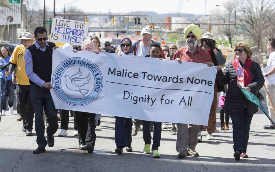 Safe Alliance for Interfaith Leaders march with a banner